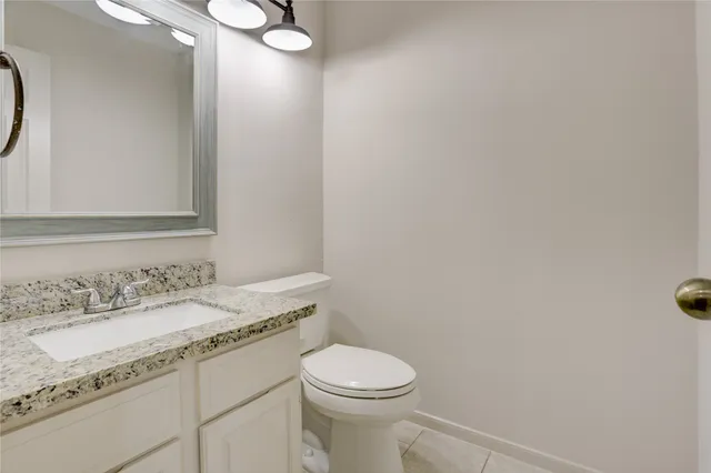 a bathroom with a granite countertop sink a toilet and a mirror