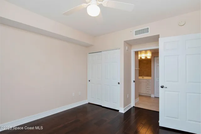 an empty room with wooden floor and closet