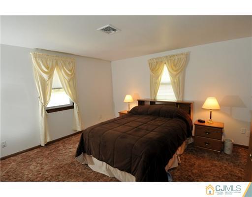 44 Idlewild Road Edison, NJ 08817 - Photo 12 of 15 a bedroom with a bed and a lamp