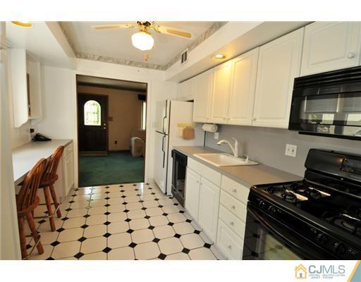 44 Idlewild Road Edison, NJ 08817 - Photo 5 of 15 a kitchen with a sink a stove and cabinets