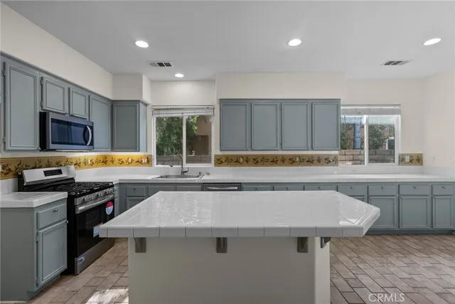 a kitchen with a sink a stove a refrigerator and a cabinets