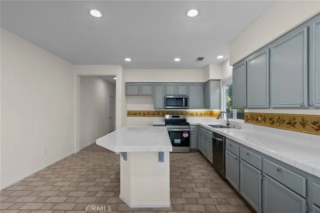 a large kitchen with stainless steel appliances kitchen island granite countertop a sink and cabinets