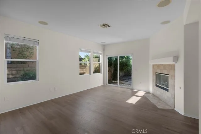 an empty room with windows and fireplace