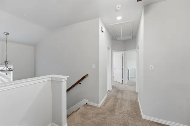 a view of a hallway with closet and a bathroom