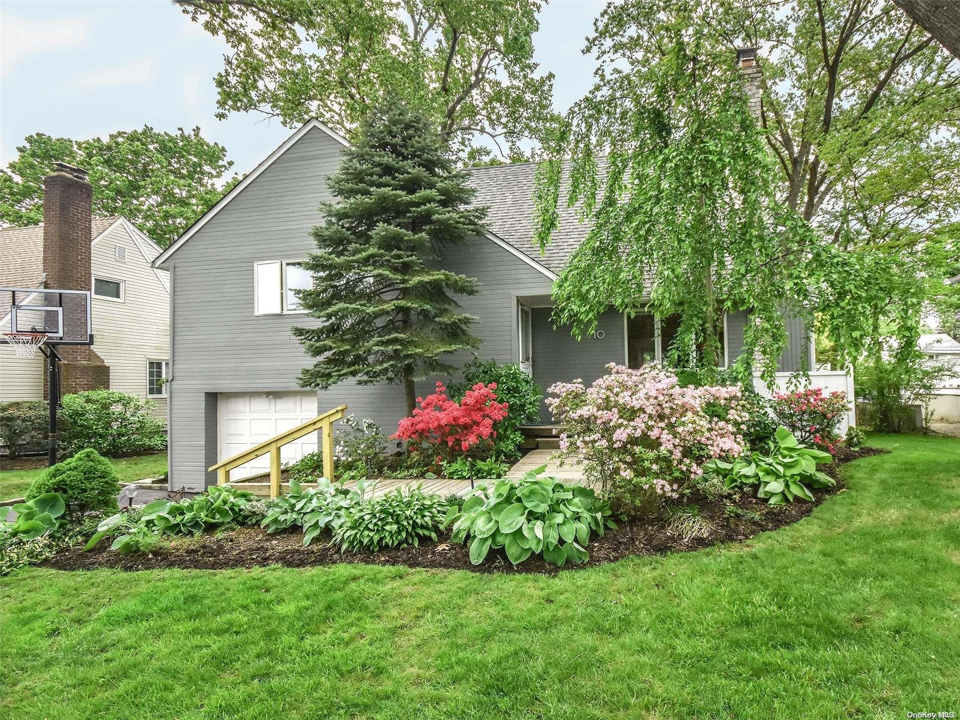 a front view of a house with a yard and plant