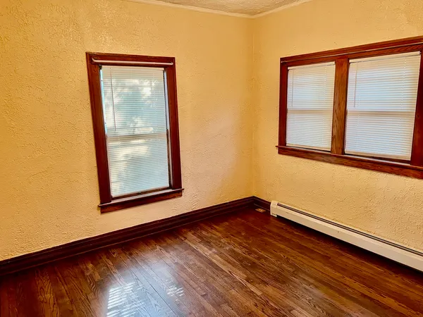 a view of a room that has wooden floor and a window