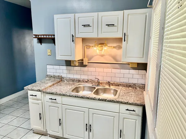 a bathroom with a granite countertop sink and a mirror