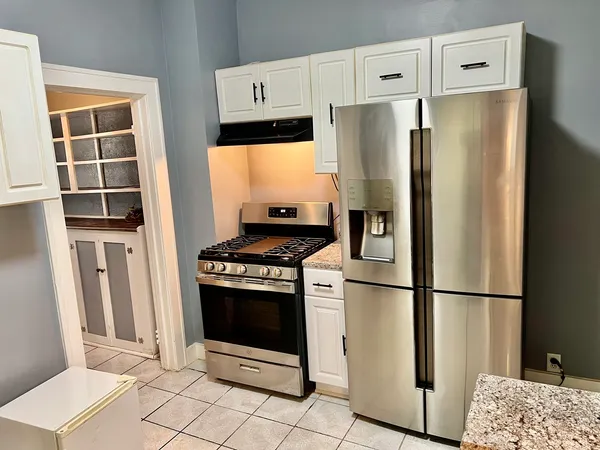 a kitchen with stainless steel appliances granite countertop a refrigerator and a stove top oven