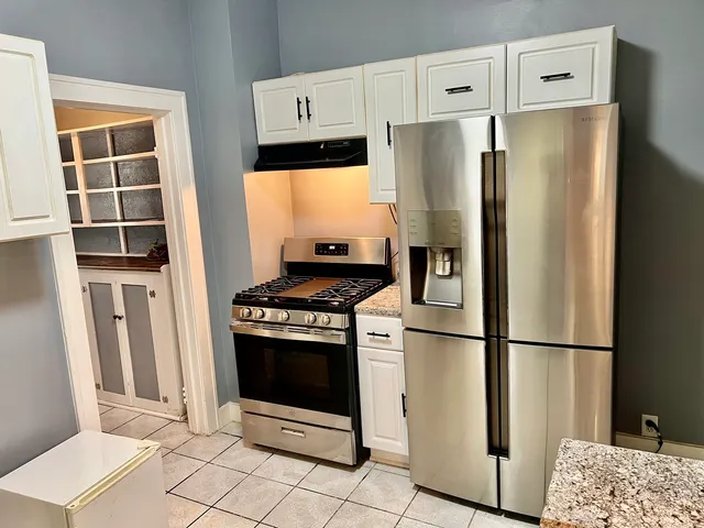 a kitchen with stainless steel appliances granite countertop a refrigerator and a stove top oven