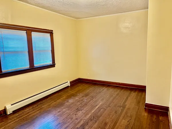 a view of a room with wooden floor and a window