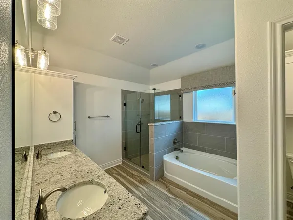 a bathroom with a granite countertop sink a mirror and a bathtub