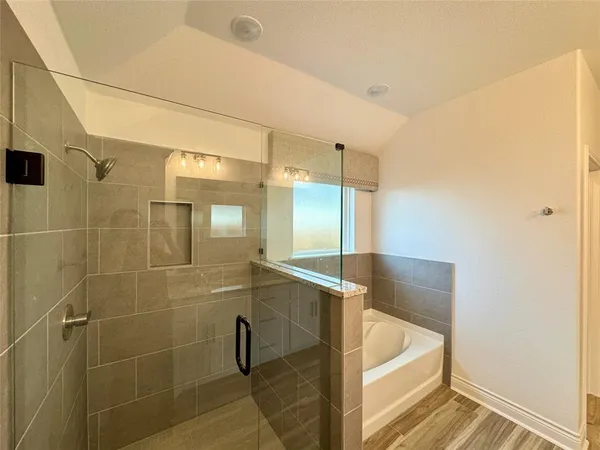 a bathroom with a tub a window and a shower