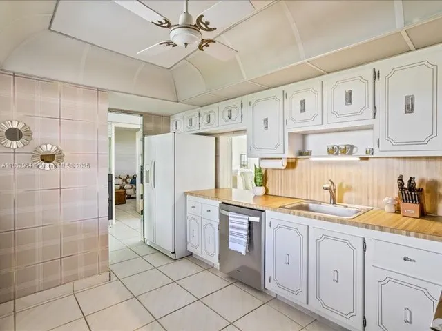 a kitchen with a sink a refrigerator and cabinets