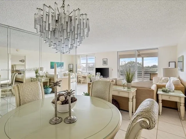 a dining room with furniture a chandelier and window