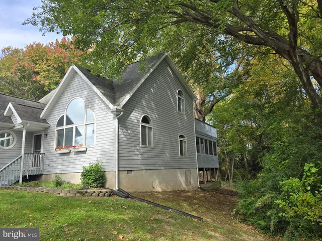 a view of a house with a yard and potted plants