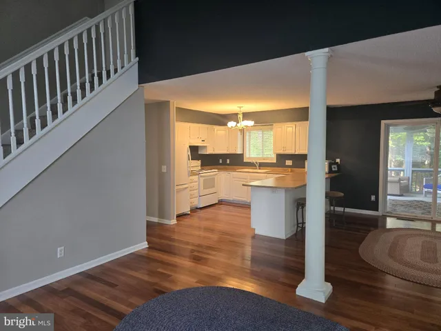 a kitchen with stainless steel appliances granite countertop a sink a stove and a wooden floor