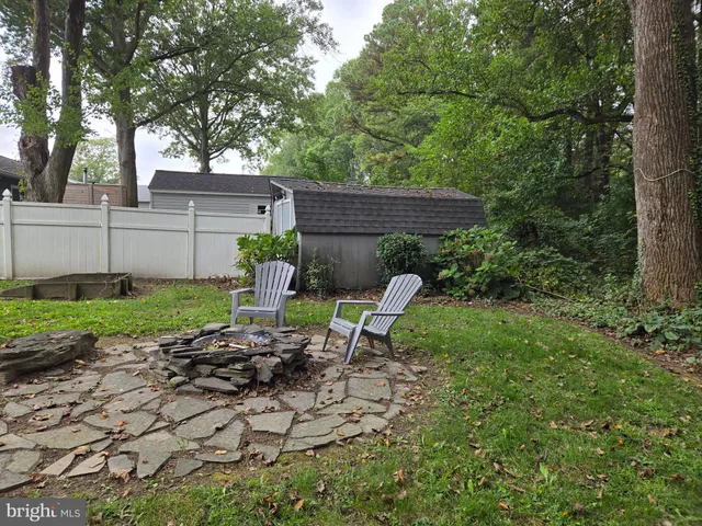 a view of backyard with table and chairs and wooden fence