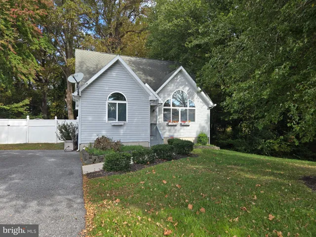 a view of house with a yard and potted plants
