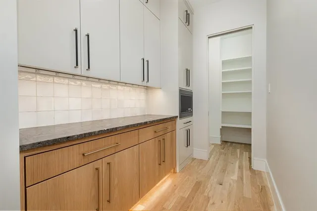 a kitchen with granite countertop white cabinets and white appliances