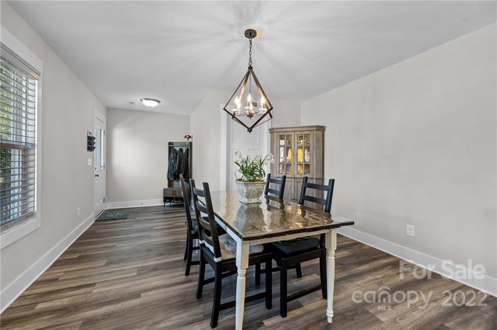 30 Rose Street York, SC 29745 - Photo 13 of 31 a dining room with wooden floor a chandelier a wooden table and chairs