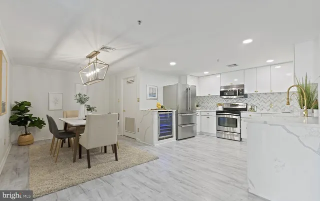 a large white kitchen with lots of counter space a sink and appliances