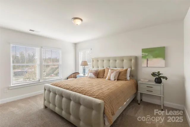 a bedroom with a bed and a large window