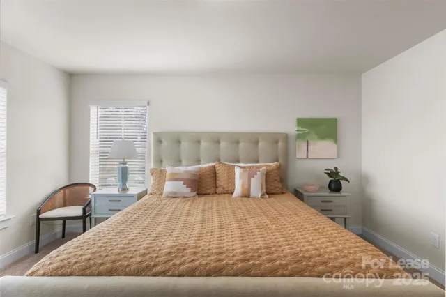 a large bed sitting in a bedroom next to a window