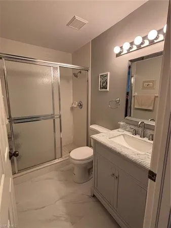 a bathroom with a double vanity sink mirror and toilet