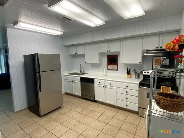 a kitchen with stainless steel appliances a refrigerator sink and cabinets