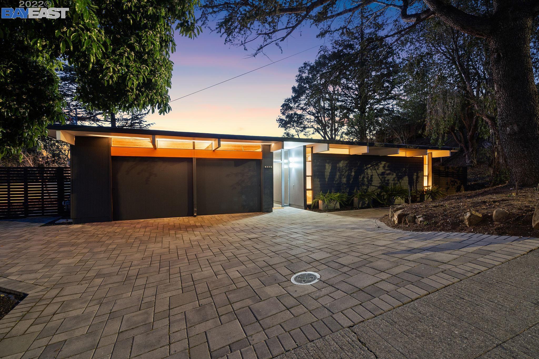 a view of backyard with large trees and a wooden fence