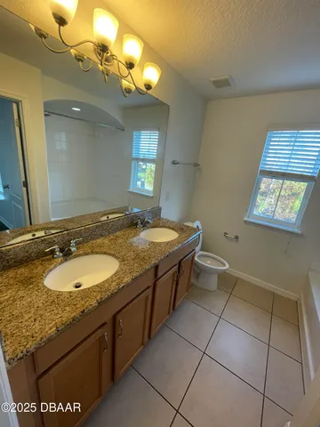 a bathroom with a granite countertop sink a mirror and a bathtub