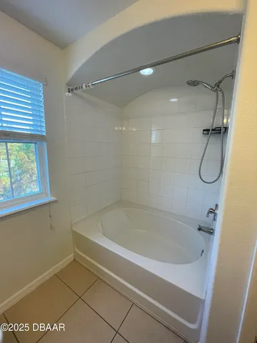 a white bath tub sitting next to a shower