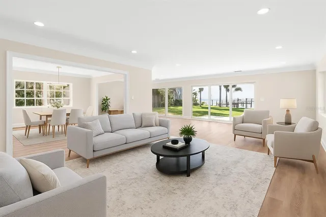 a kitchen with stainless steel appliances a refrigerator a sink a stove a dining table and chairs