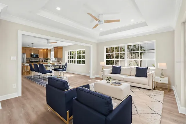 a kitchen with stainless steel appliances granite countertop a refrigerator a sink dishwasher a stove top oven a refrigerator with white cabinets and wooden floor