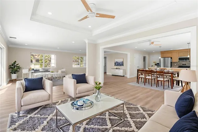 a living room with furniture floor to ceiling window and a flat screen tv