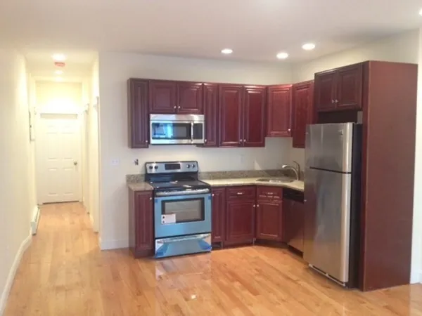 a kitchen with stainless steel appliances granite countertop a refrigerator stove and a sink