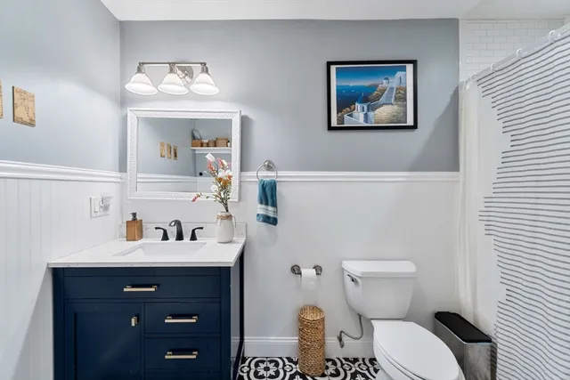 a bathroom with a toilet a sink and mirror