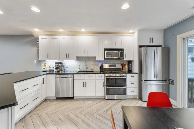 a kitchen with granite countertop a refrigerator stove top oven and sink