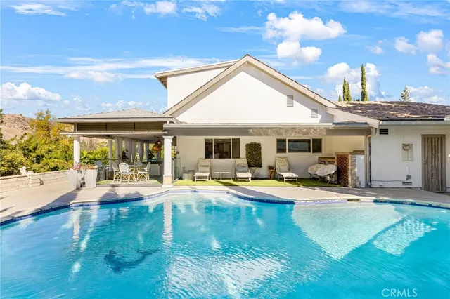 a view of a house with swimming pool and sitting area