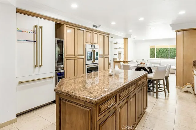 a kitchen with granite countertop a table chairs stove and refrigerator