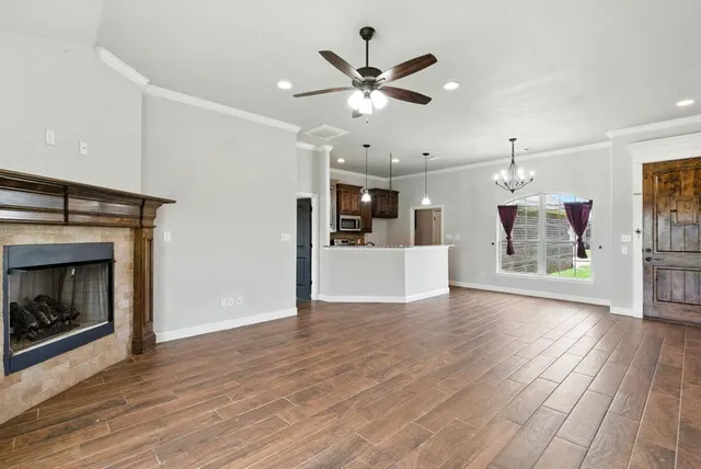 a view of a kitchen with a ceiling fan wooden floor and a fireplace