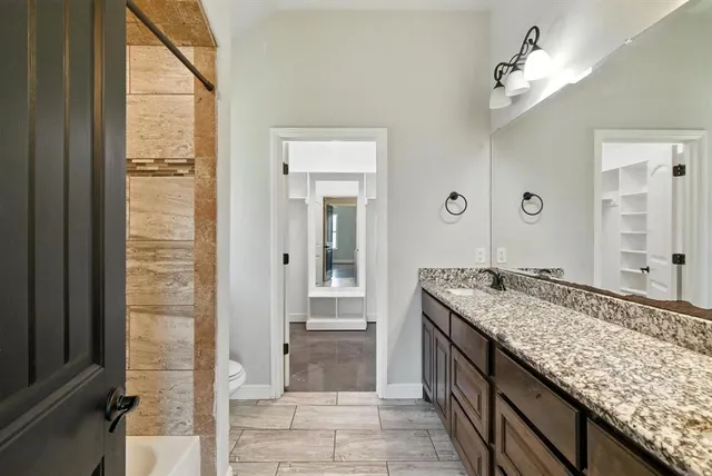 a bathroom with a granite countertop sink and a mirror