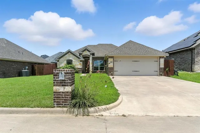 a front view of a house with a garden and yard