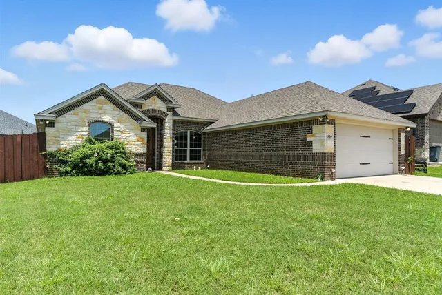 a front view of a house with a garden