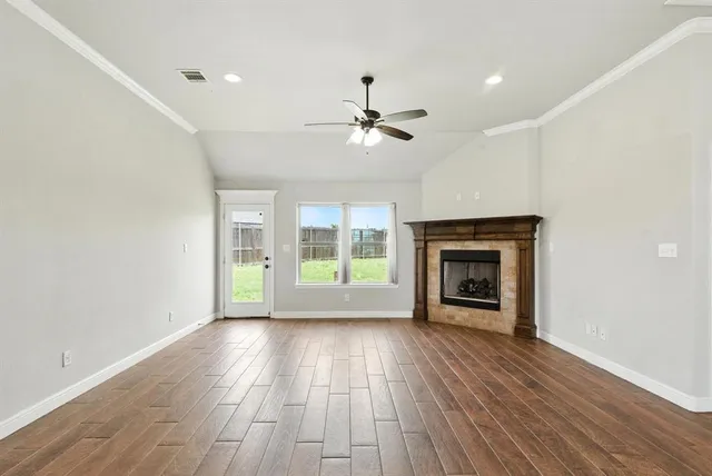 a view of an empty room with a fireplace and a window