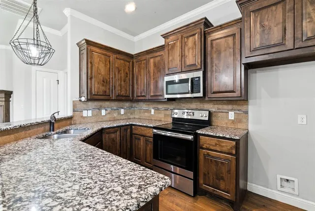 a kitchen with stainless steel appliances granite countertop a stove a sink and a microwave
