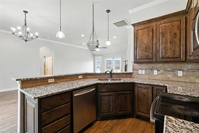 a kitchen with a sink and chandelier