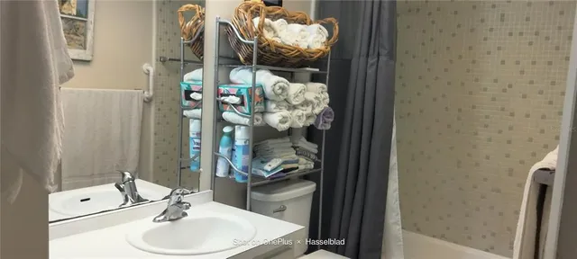 a bathroom with a sink vanity mirror and toilet