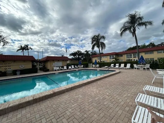 a view of a swimming pool with a patio and a yard