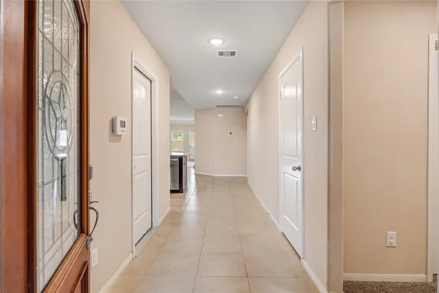 a view of a hallway with wooden cabinets